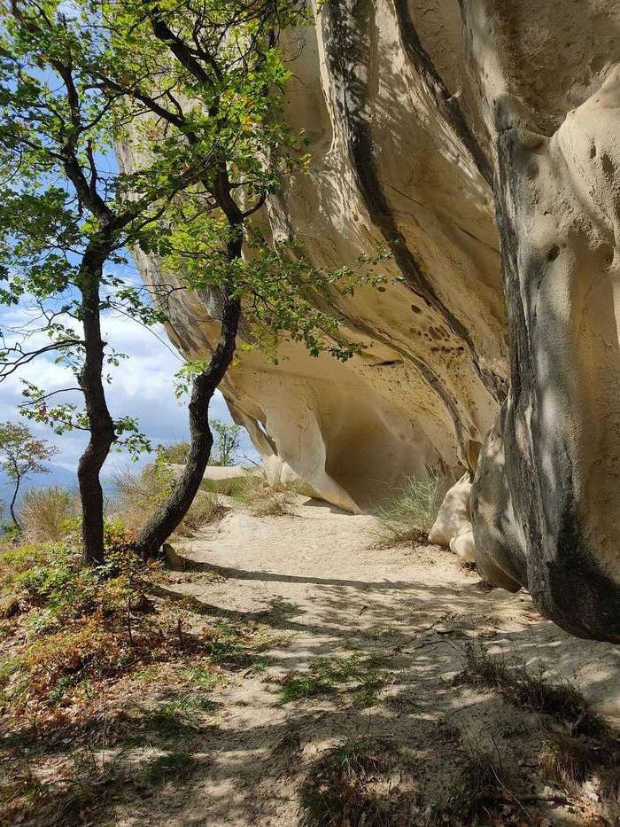 Ein Weg unter Sandsteinfelsen im Bologneser Apennin